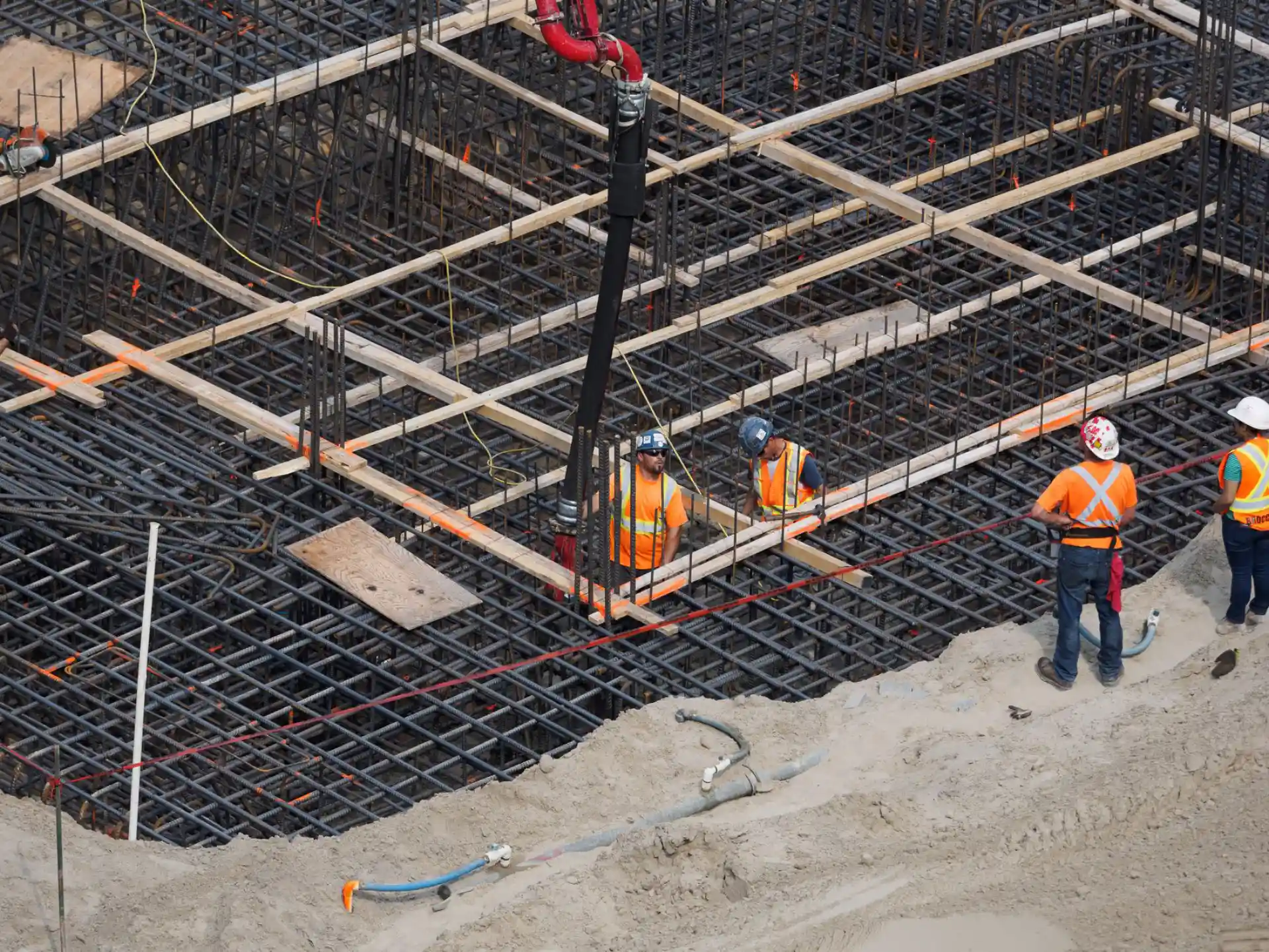 Reinforcing steel mat over a large foundation excavation with a crane working overhead