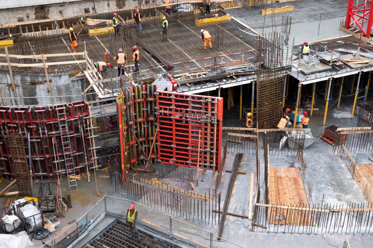Foundation site with formwork panels and reinforcement, a crew working between them