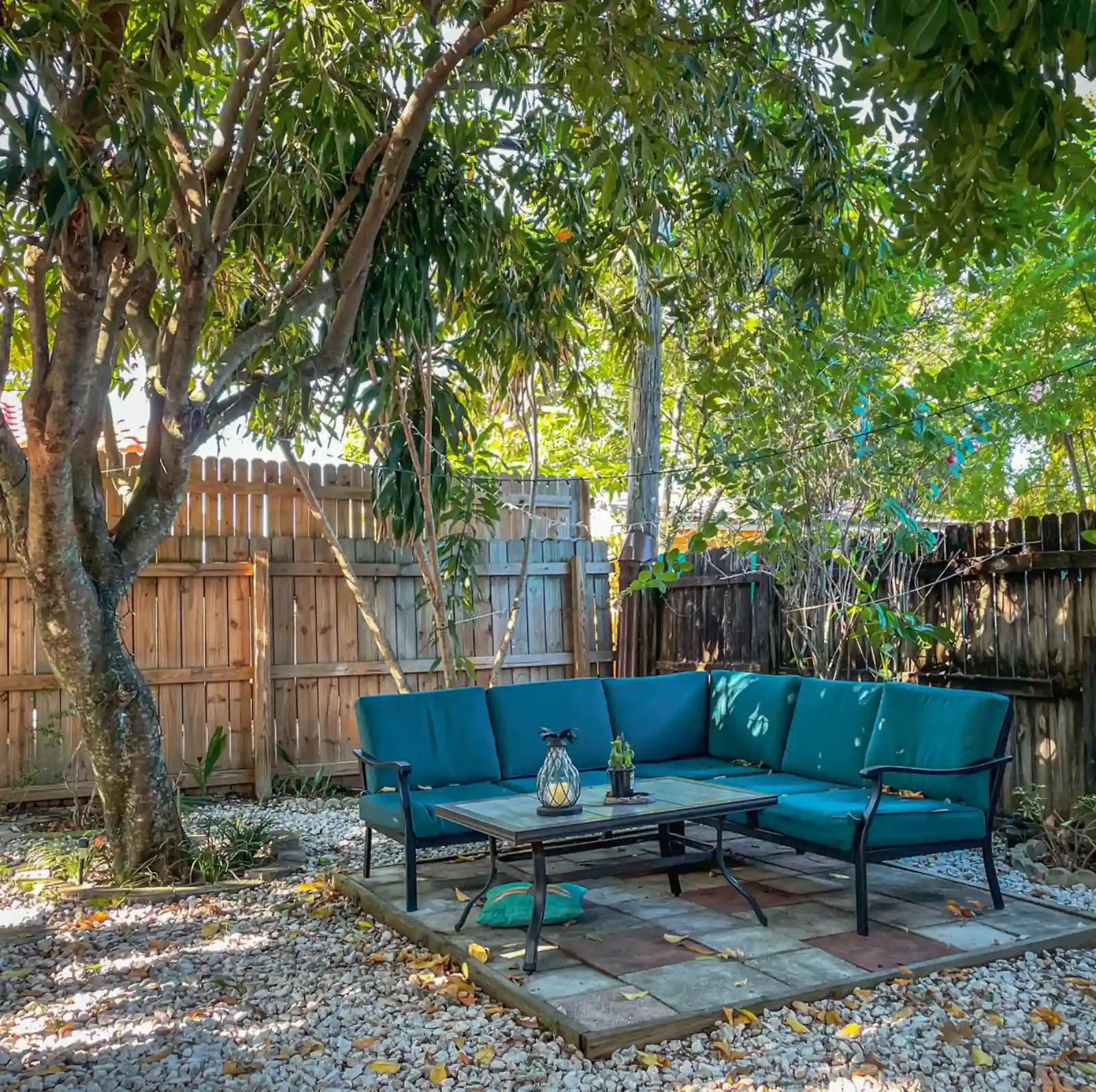 Concrete patio slab in a fenced backyard with outdoor seating on it