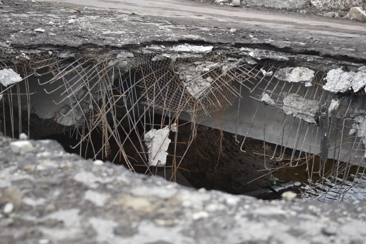 Broken concrete over a washed-out void beneath the slab