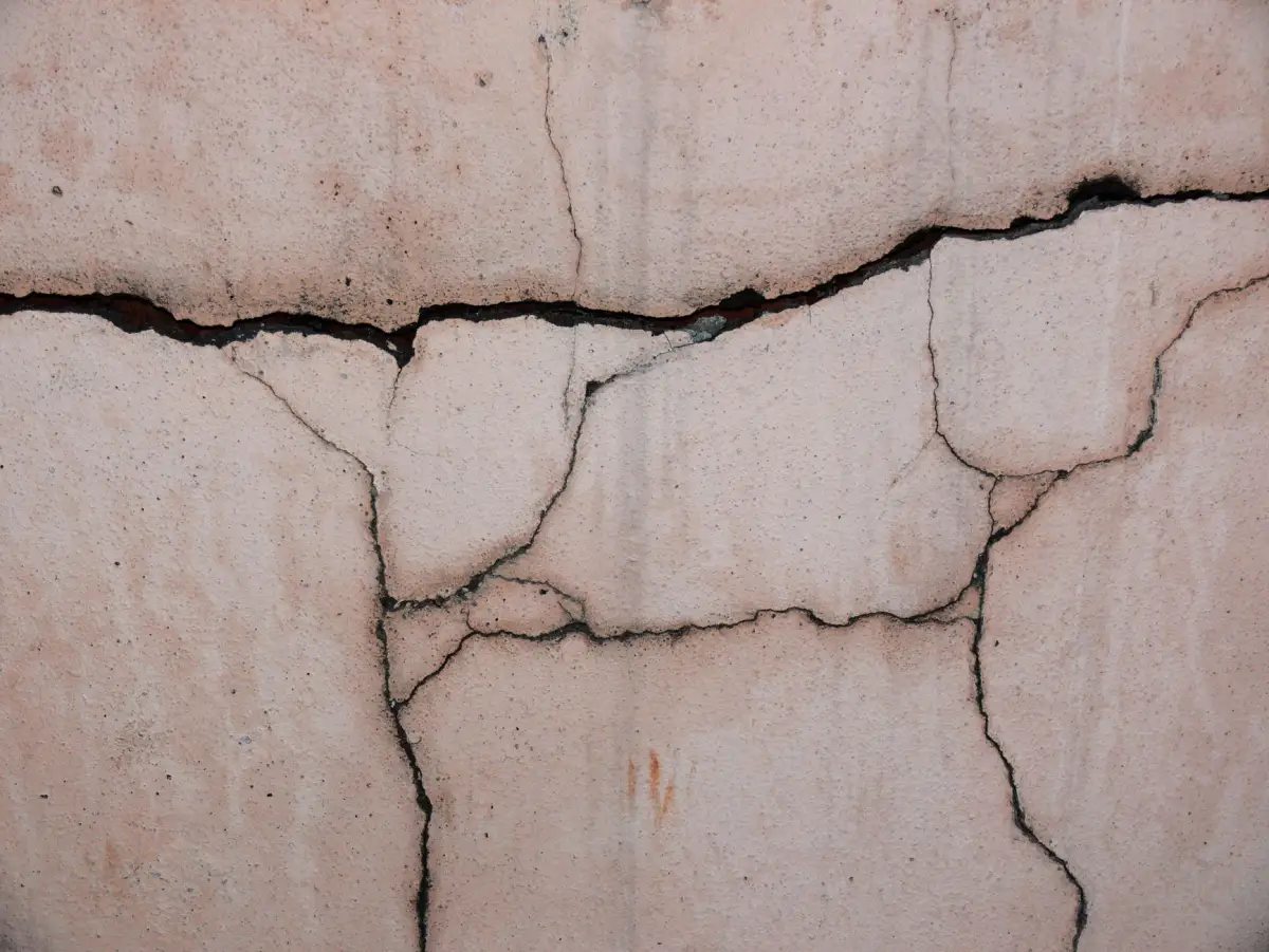 Cracks running across a weathered concrete slab surface