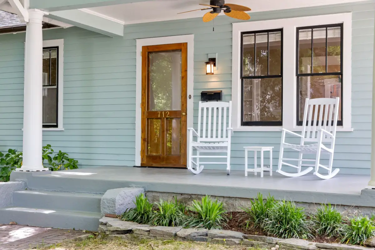 Concrete porch slab and step at a house with rocking chairs on the porch