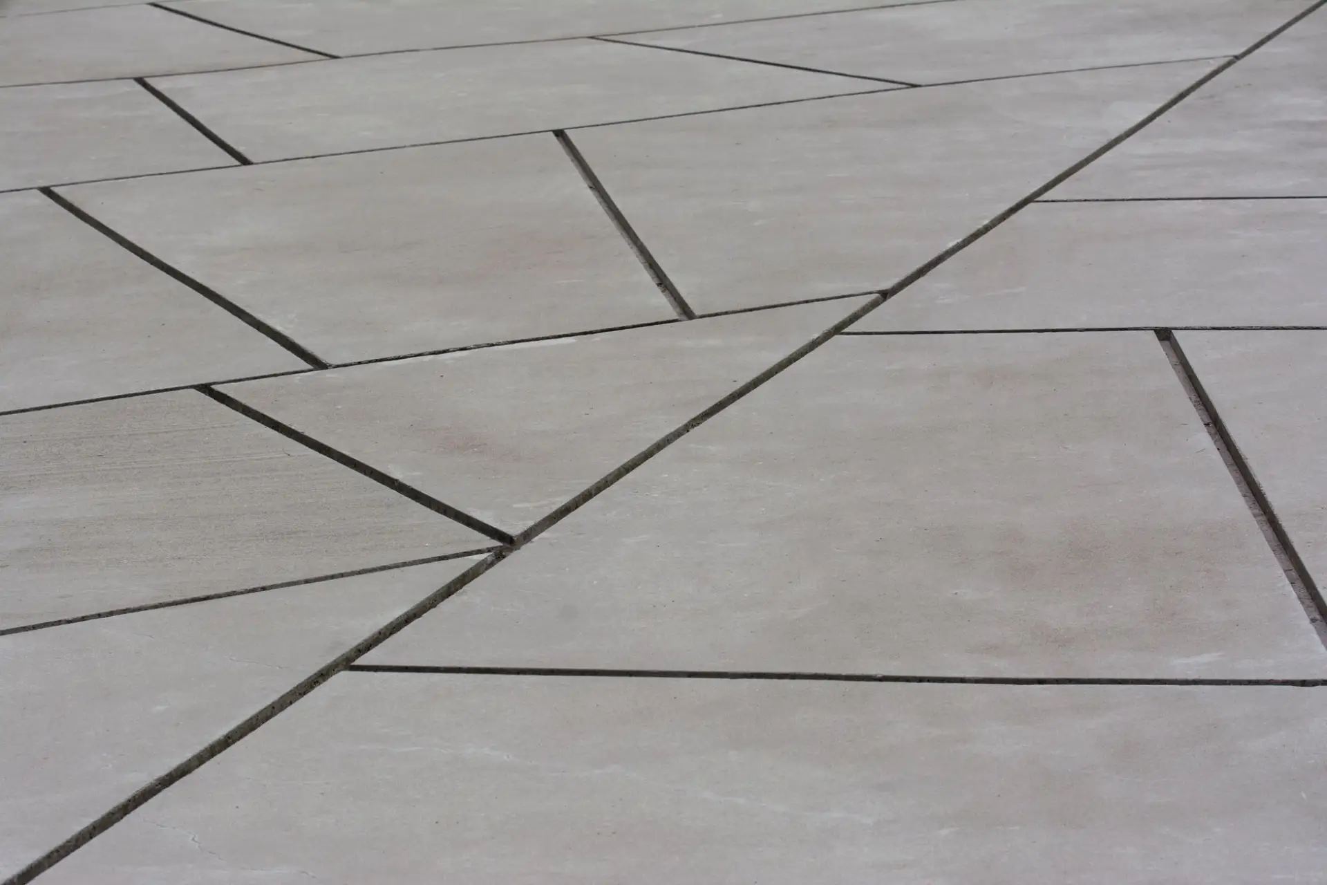 Concrete plaza laid out in angular panels defined by saw-cut joints