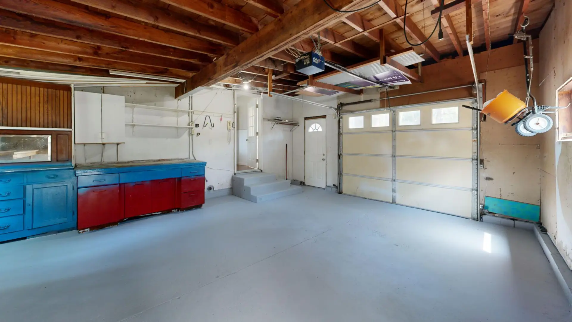 Detached garage interior with a bare concrete floor and a workbench along one wall