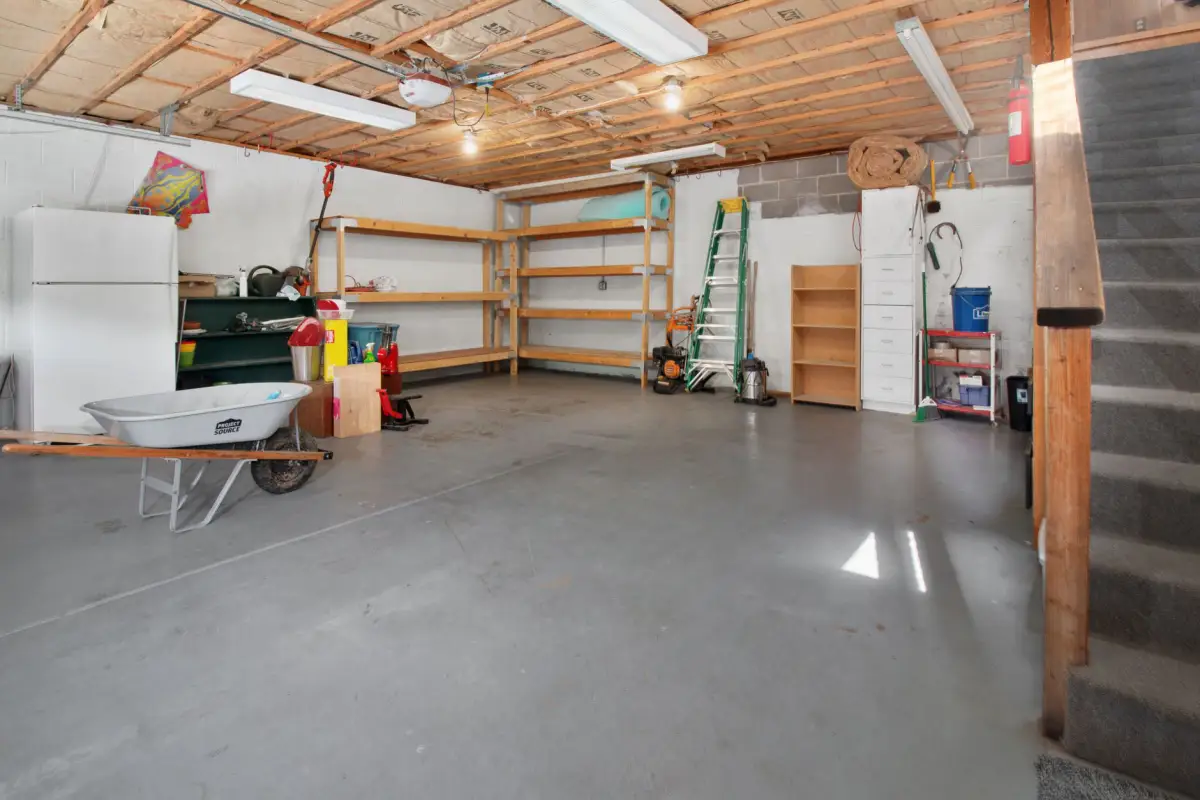 Clean concrete garage floor in a residential garage with shelving along the back wall